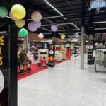 Iluminación general de retail con líneas de luz LED y focos proyectores orientables sobre estanterías.