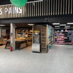 Luminarias lineales de alta eficiencia en la sección de panadería de un supermercado.
