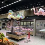 Líneas de luz LED integradas sobre vitrinas refrigeradas en sección de alimentación.