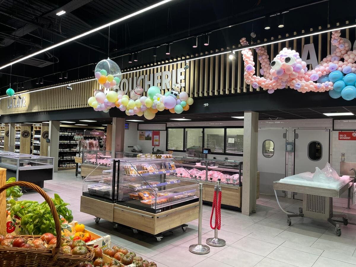 Líneas de luz LED integradas sobre vitrinas refrigeradas en sección de alimentación.