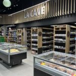 Perspectiva de iluminación lineal para grandes superficies y pasillos de supermercados.