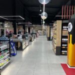 Luminarias lineales suspendidas de bajo deslumbramiento en pasillo de alimentos frescos.