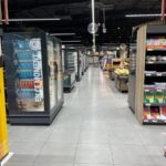Iluminación de acento para destacar productos en expositores de madera y mimbre.
